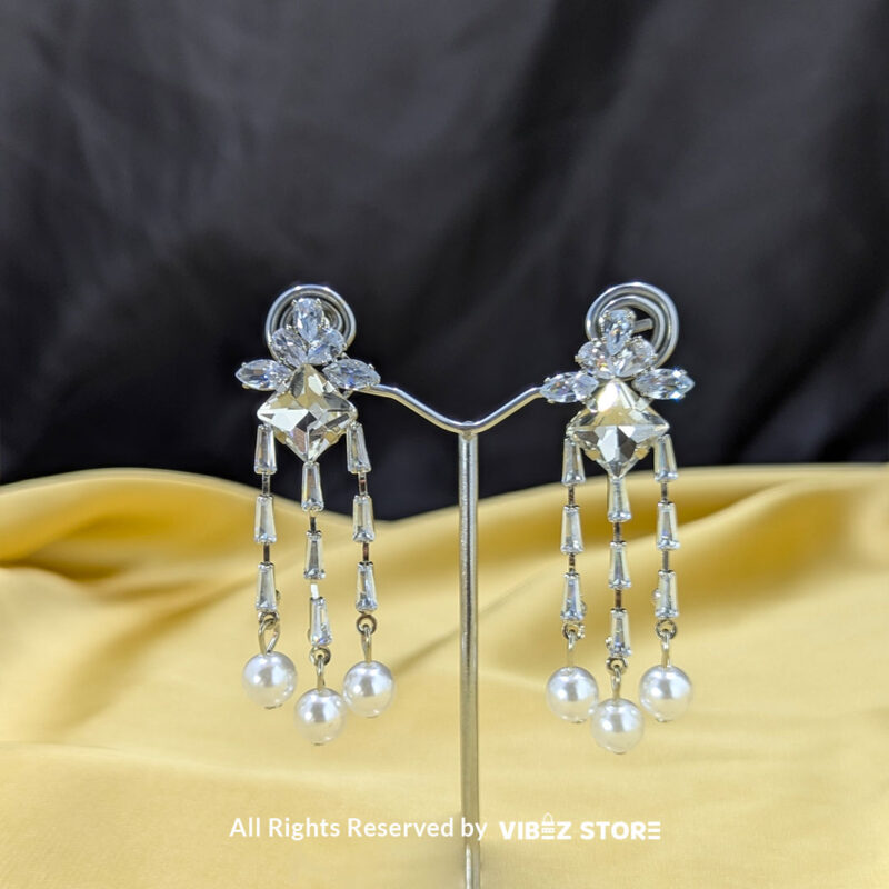 Crystal dangle earrings with floral embellishments and pearl drops, displayed elegantly by Vibez Store.