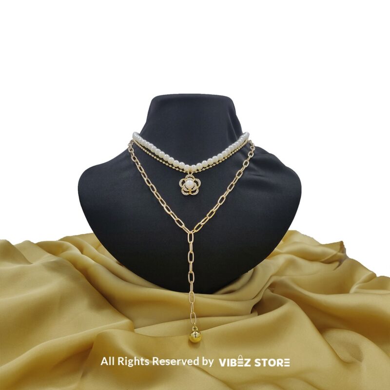 Pearl and gold chain layered necklace with flower pendant displayed on black bust