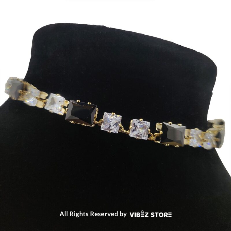 Square-stone choker necklace with matching earrings on display, featuring alternating black and clear stones