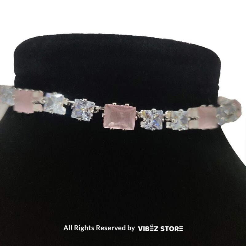 Square-stone choker necklace with matching earrings on display, featuring alternating black and clear stones