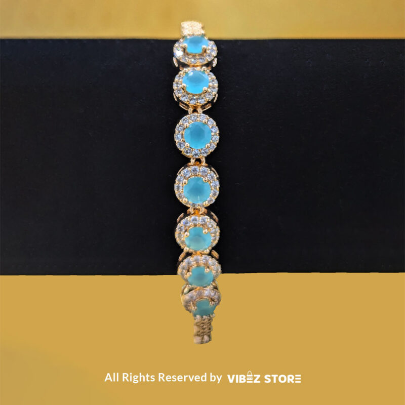 Gold-tone jewelry set with aqua blue gemstones, including a necklace, earrings, bracelet, and ring, elegantly displayed by Vibez Store.