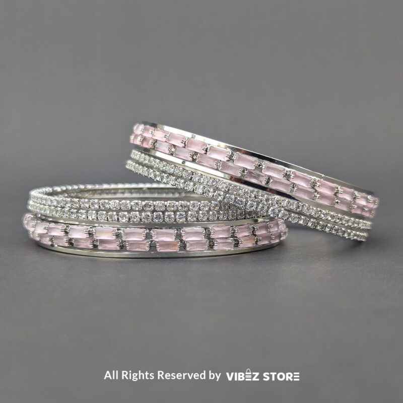 Silver bangles set with pink rectangular crystals and shimmering white stones.