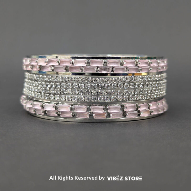 Silver bangles set with pink rectangular crystals and shimmering white stones.