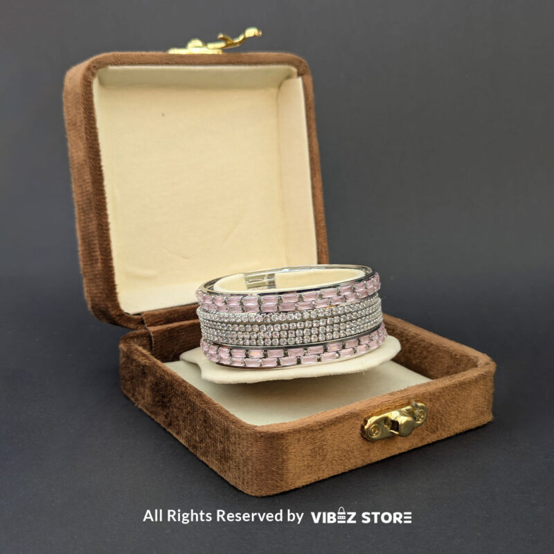 Silver bangles set with pink rectangular crystals and shimmering white stones.