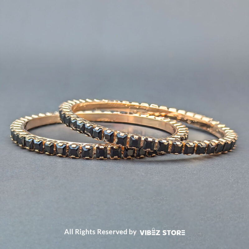 Rose gold bangles set with black crystals for party wear.