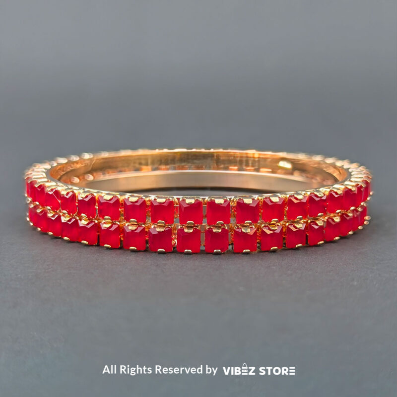 Rose gold bangles set with vibrant red crystals for festive and party wear.