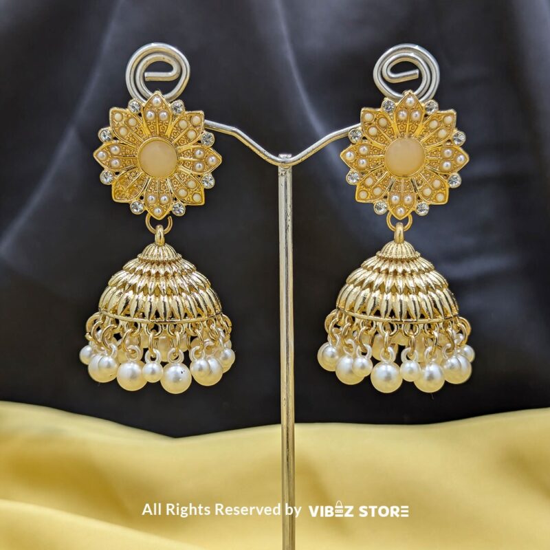 Gold-tone jhumka earrings with floral motifs, pearl drops, and a secure push-back closure, displayed with intricate detailing and a traditional design.