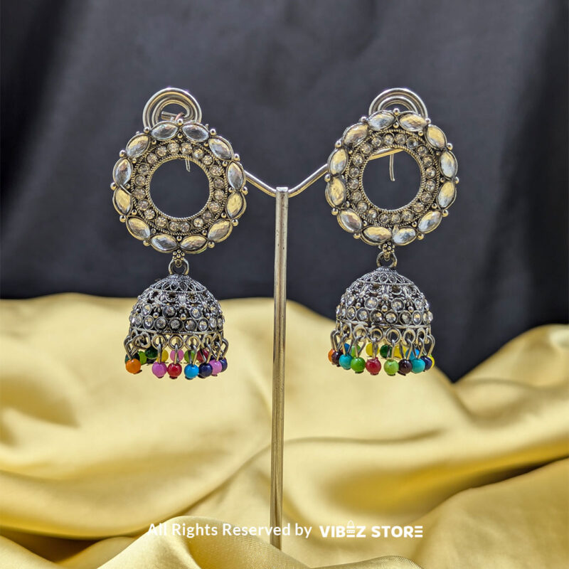 Silver-plated kundan jhumka earrings with crystal detailing and multicolor bead accents on a circular design, perfect for weddings and festivals.