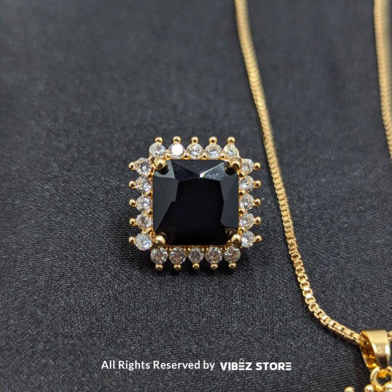 Black square pendant jewelry set featuring a necklace with a gold chain and matching stud earrings adorned with cubic zirconia.