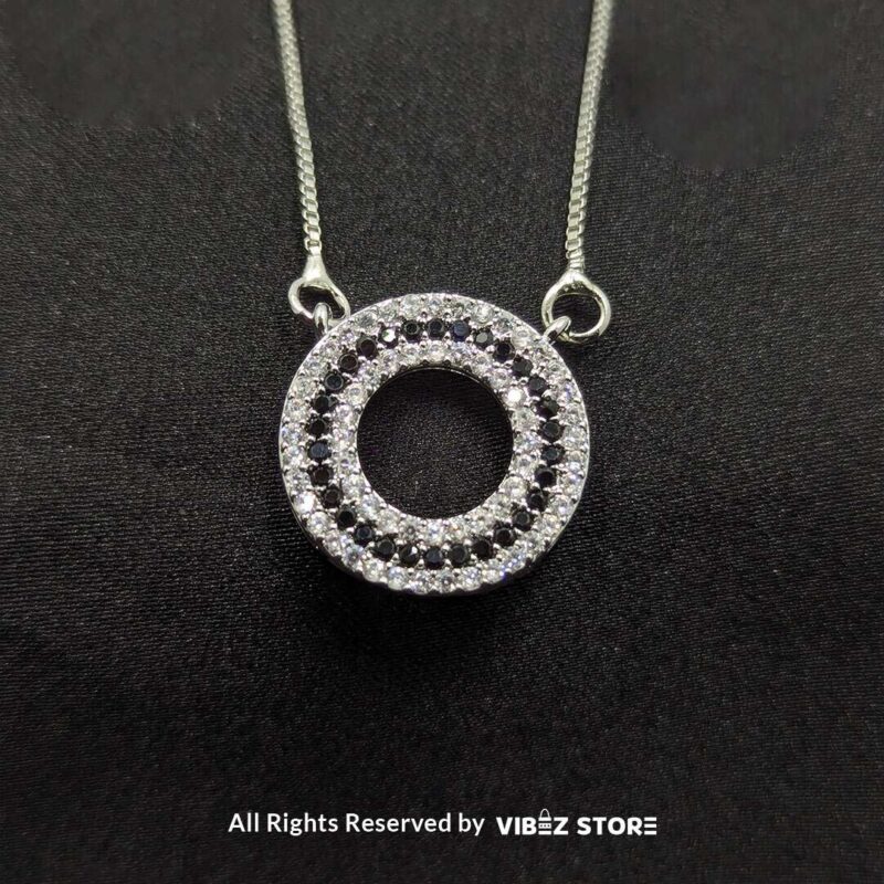 Silver round pendant jewelry set with a delicate chain necklace and matching circular stud earrings, adorned with cubic zirconia stones.

