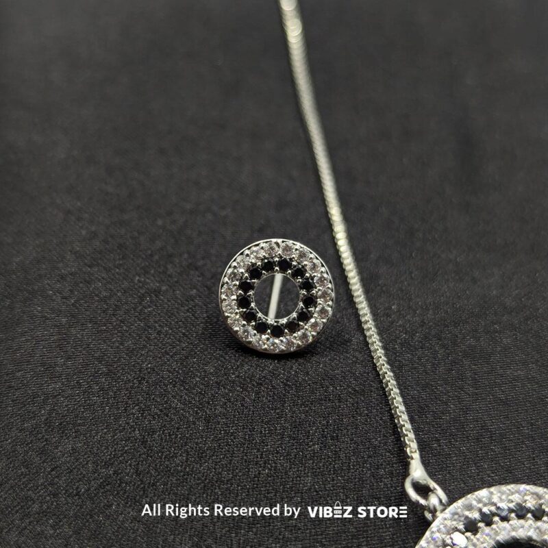 Silver round pendant jewelry set with a delicate chain necklace and matching circular stud earrings, adorned with cubic zirconia stones.

