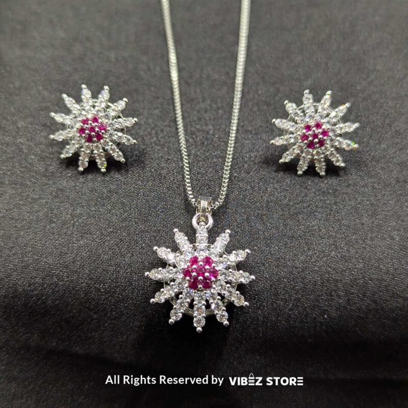 Ruby sunflower jewelry set with a sparkling pendant and earrings featuring ruby-colored accents on a sleek black backdrop.