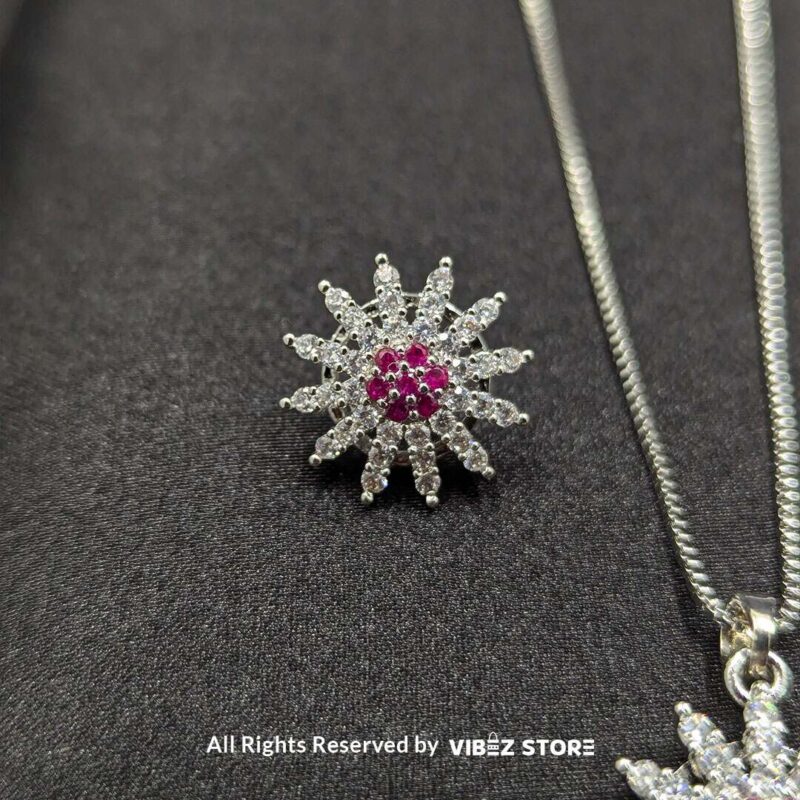 Ruby sunflower jewelry set with a sparkling pendant and earrings featuring ruby-colored accents on a sleek black backdrop.