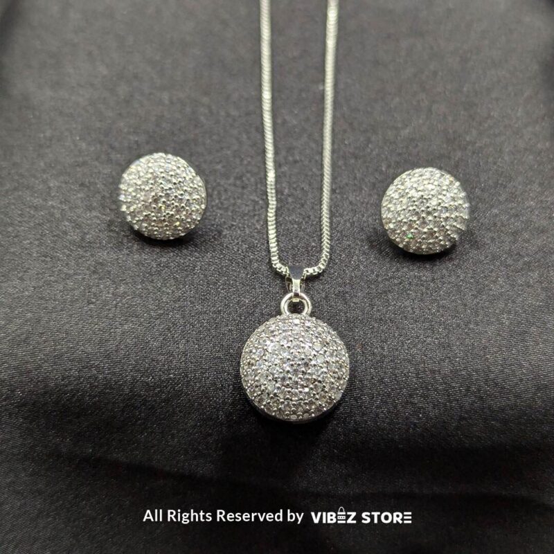 Sphere-shaped pendant and earrings set featuring shimmering crystals, displayed on a sleek black backdrop. Available in multiple color variations.