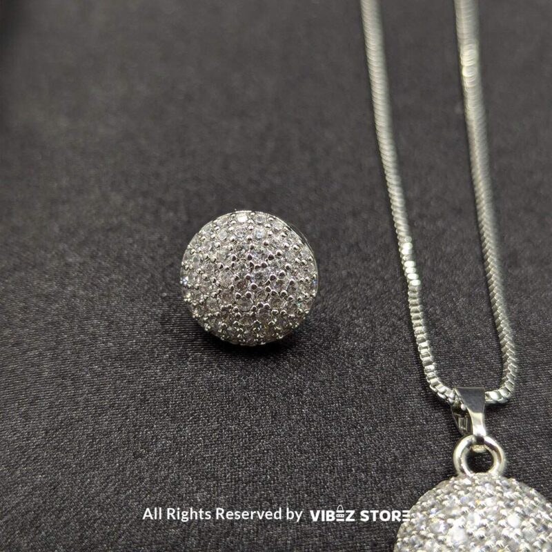 Sphere-shaped pendant and earrings set featuring shimmering crystals, displayed on a sleek black backdrop. Available in multiple color variations.