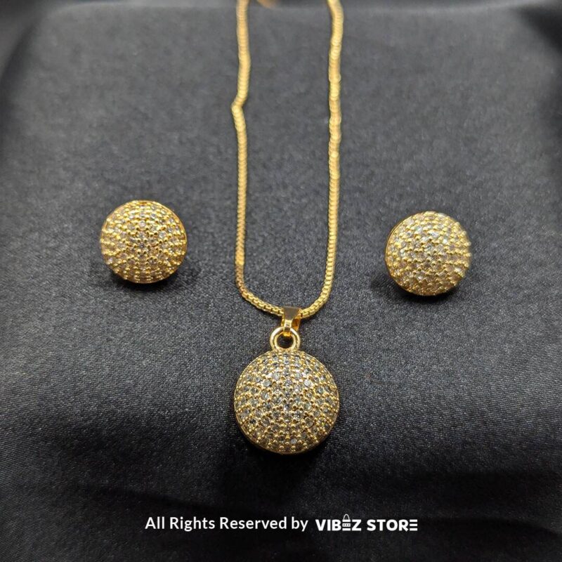 Sphere-shaped pendant and earrings set featuring shimmering crystals, displayed on a sleek black backdrop. Available in multiple color variations.