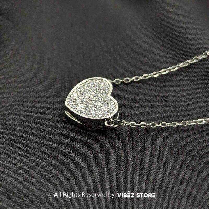 Close-up of a magnetic silver heart locket necklace with rhinestone accents and a secure magnetic clasp.