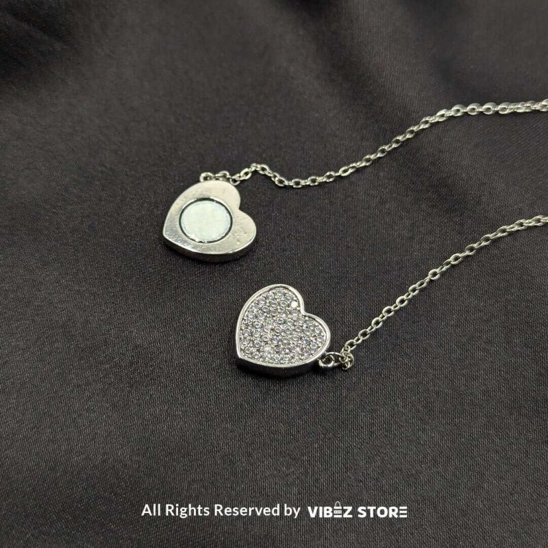 Close-up of a magnetic silver heart locket necklace with rhinestone accents and a secure magnetic clasp.