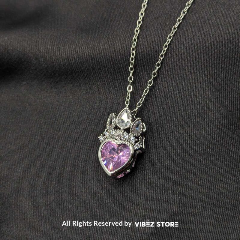 Crown heart locket with a pink gemstone centerpiece and intricate silver crown detailing.