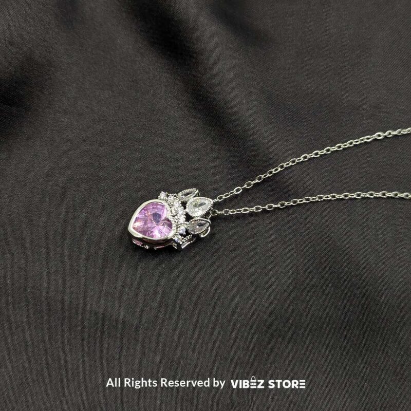 Crown heart locket with a pink gemstone centerpiece and intricate silver crown detailing.