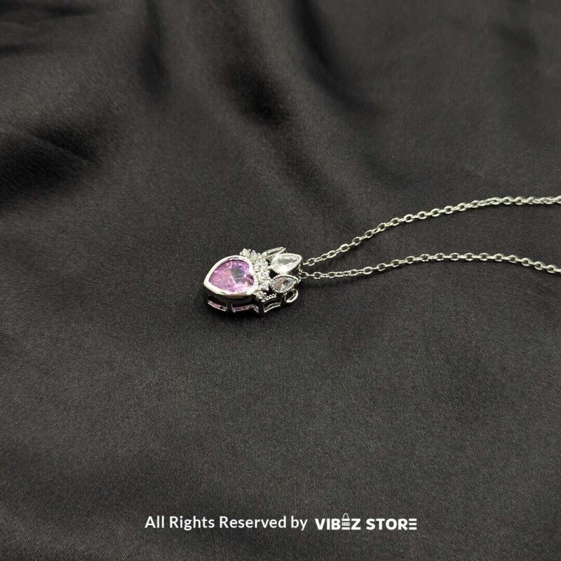 Crown heart locket with a pink gemstone centerpiece and intricate silver crown detailing.