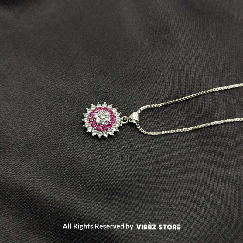 A collection of three gemstone lockets in clear, gold-pink, and silver-pink tones, each surrounded by a dazzling crystal halo, displayed on a black fabric background.