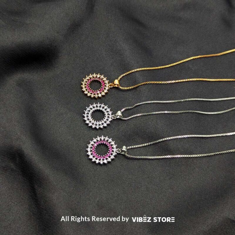 Three round cluster crystal lockets in gold, silver, and silver-pink designs displayed elegantly on a black fabric background.