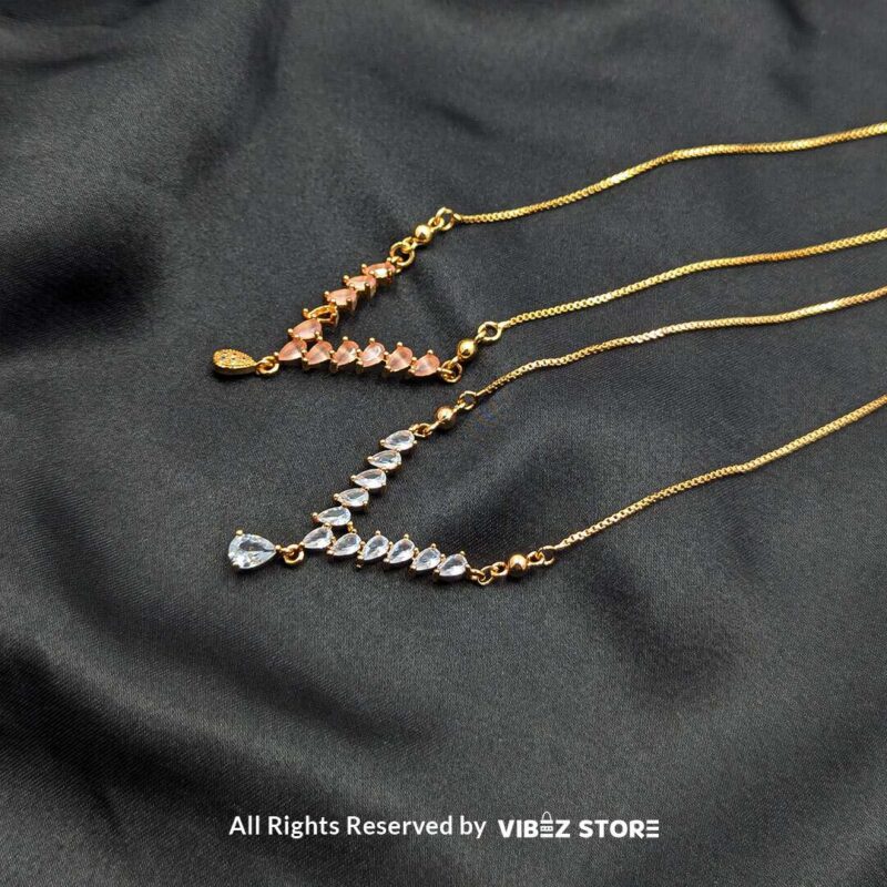 Three heart crystal V-shaped lockets in rose-gold, white-silver, and gold tones elegantly displayed on a black fabric background.