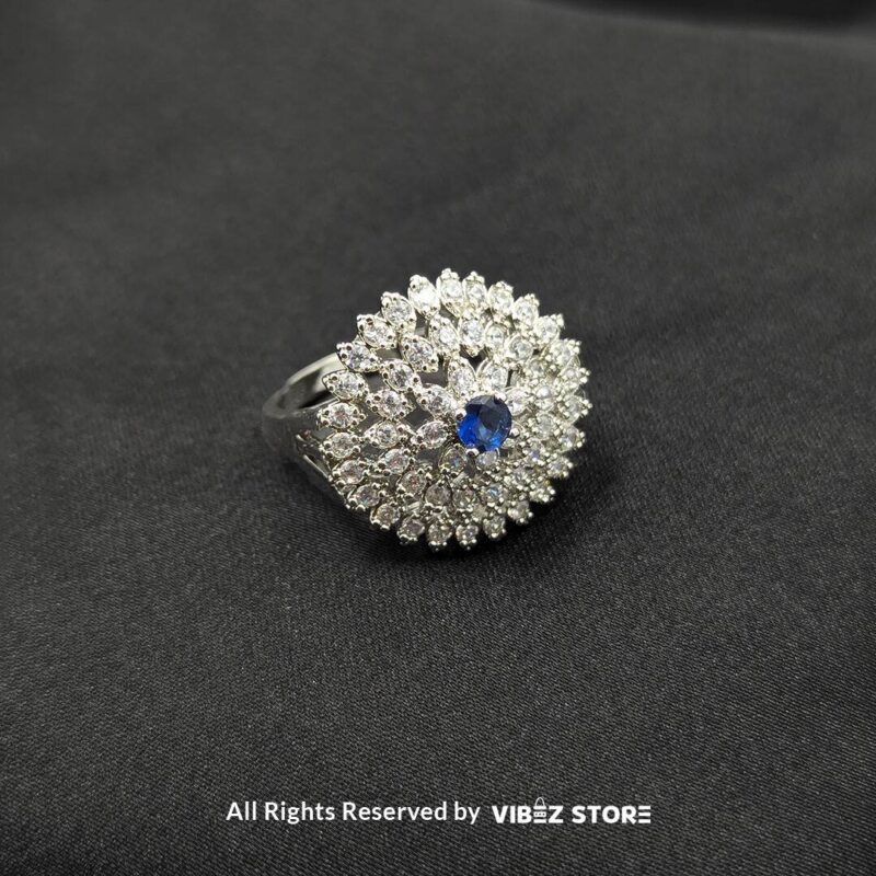 Silver-tone floral rings with crystal accents and central gemstones in sapphire blue, clear crystal, and jet black, beautifully displayed by Vibez Store.