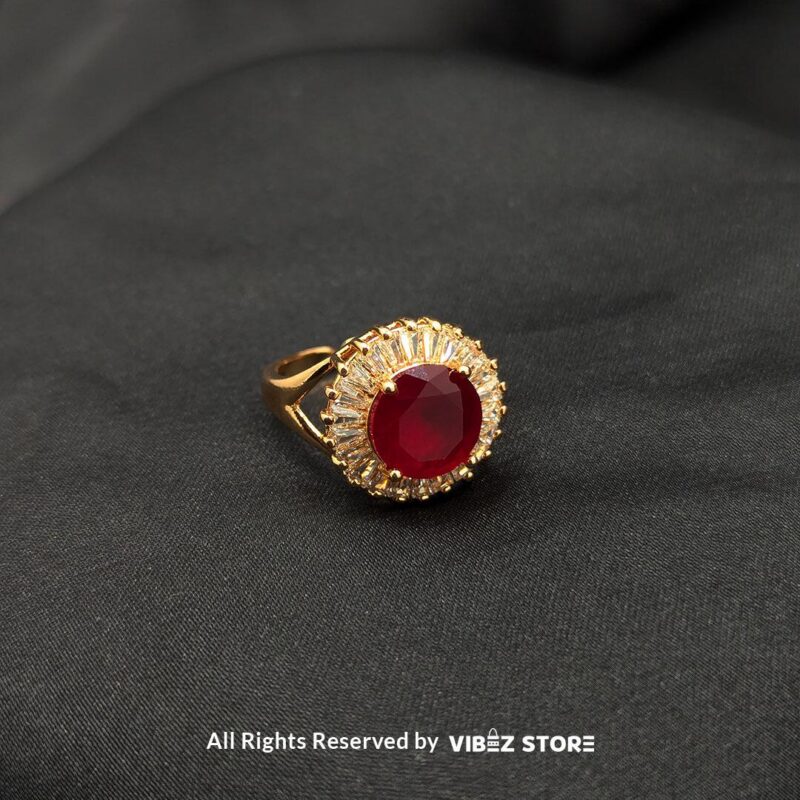 A luxurious gold-tone ring with a ruby-red centerpiece encircled by a sparkling crystal halo, from Vibez Store.