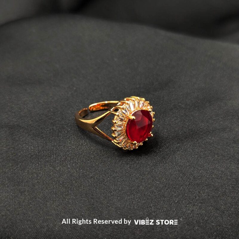 A luxurious gold-tone ring with a ruby-red centerpiece encircled by a sparkling crystal halo, from Vibez Store.